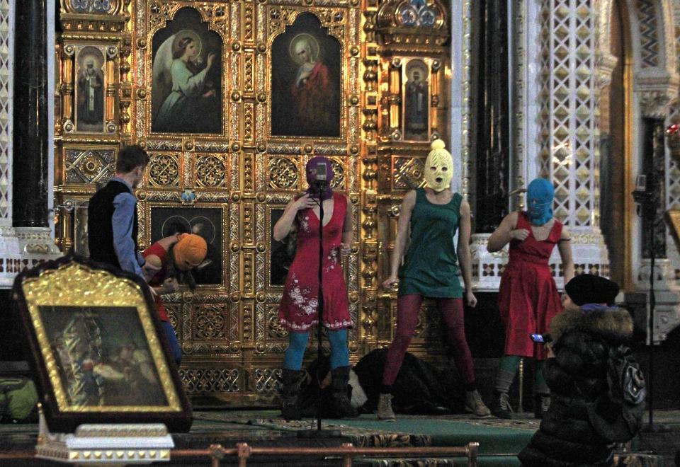 In this Feb. 21, 2012 file photo, members of the Russian radical feminist group Pussy Riot try to perform at the Christ the Saviour Cathedral in Moscow. (AP Photo/Sergey Ponomarev, File)