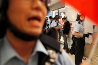 A protester is detained by the police officers at Amoy Plaza shopping mall in Kowloon Bay, Hong Kong