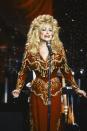 <p>Dolly dazzles here in a brick red dress embellished with a variety of golden accents for a performance on "The Johnny Carson Show." She plays up the country-fied style of the 1970s in a more modern way for the '80s. </p>