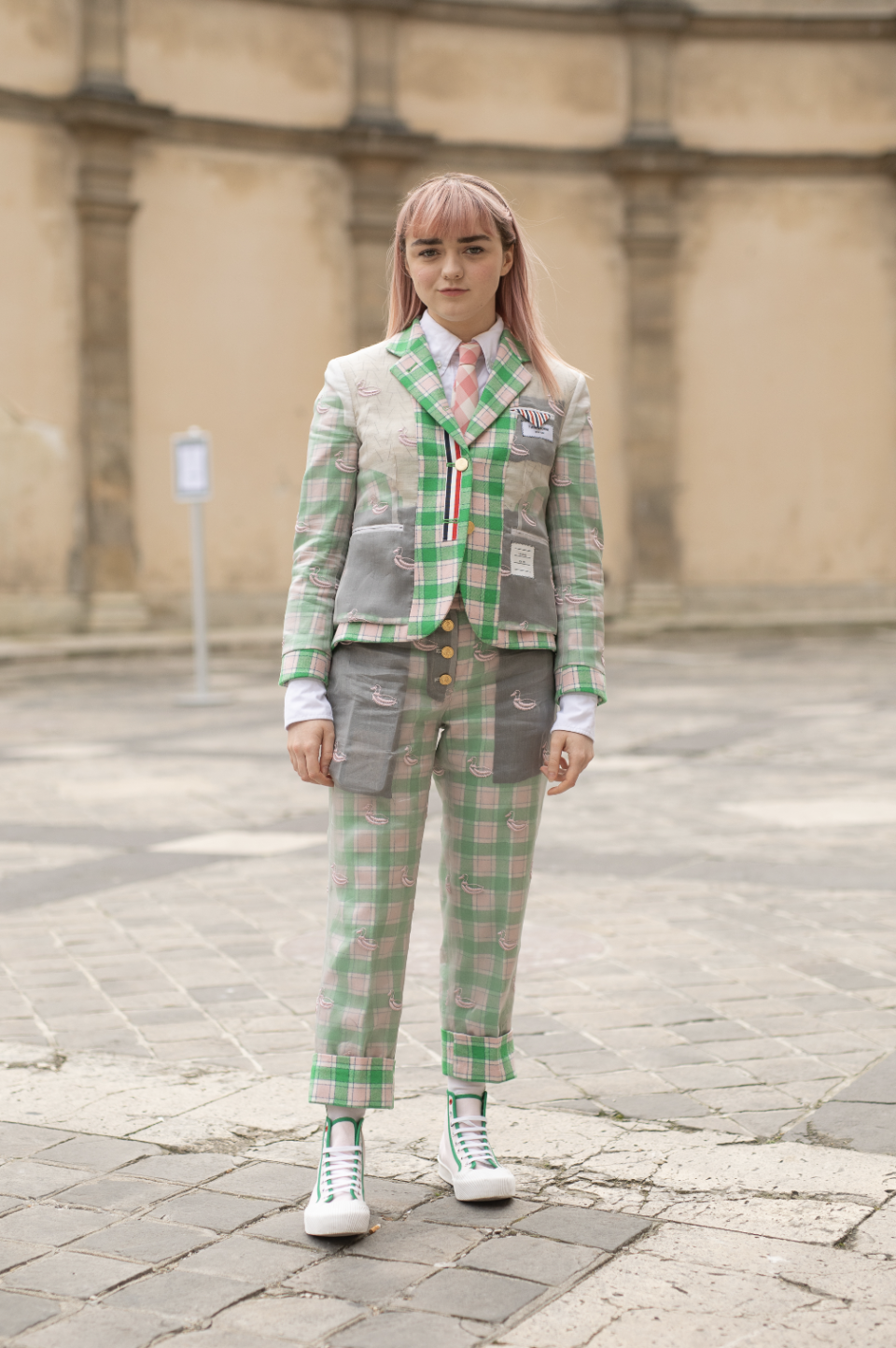 <p>Maisie Williams wore a green and pink Thom Browne suit with matching high top trainers at the label’s AW19 show during Paris Fashion Week. <em>[Photo: Getty]</em> </p>