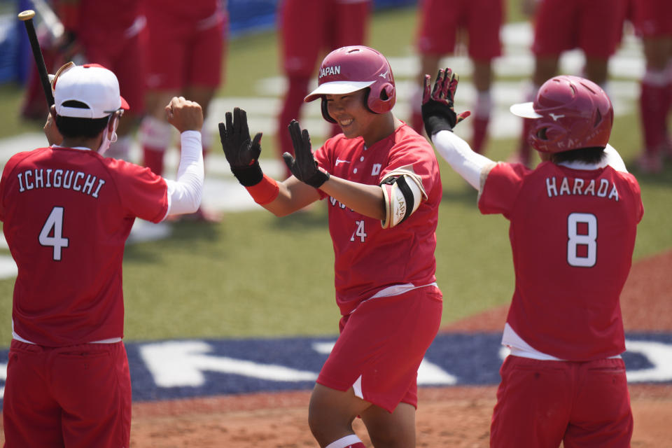 Japan's Minori Naito, center, celebrates with her teammates after hitting a two run home run during the softball game between Japan and Australia at the 2020 Summer Olympics, Wednesday, July 21, 2021, in Fukushima, Japan. (AP Photo/Jae C. Hong)