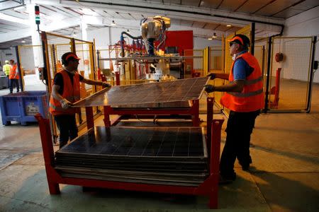 Employees work at Veolia’s solar panel recycling plant in Rousset, France, June 25, 2018. At the plant, photovoltaic panels are dissembled and their constituent parts such as glass, aluminium, silicon and plastics are recycled. REUTERS/Jean-Paul Pelissier