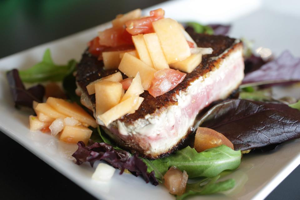 Seared citrus tuna with a coriander citrus rub and melon pico de gallo, served atop a bed of field greens with choice of side from Pure Eatery.