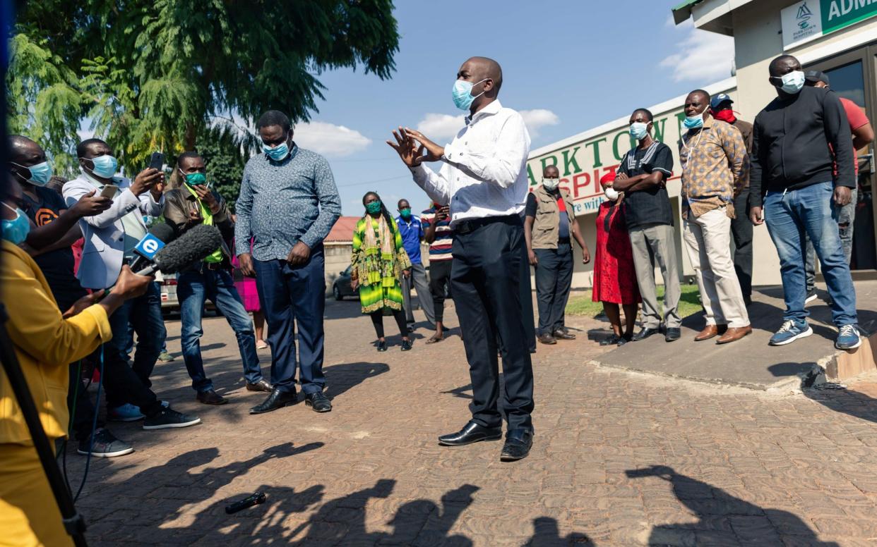 Zimbabwean opposition party leader Nelson Chamisa (centre) speaks with journallists gathered outside a private hospital in Harare on May 15, 2020, where three youth leaders from the Movement for Democratic Change (MDC) Alliance were admitted after allegedly being abducted and beaten up by police and eventually dumped along the roadside some ways from the capital city. - JEKESAI NJIKIZANA/AFP