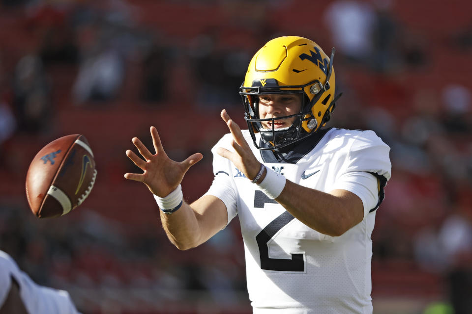 West Virginia's Jarret Doege (2) catches the snap during the first half of an NCAA football game on Saturday, Oct. 24, 2020, in Lubbock, Texas. (AP Photo/Brad Tollefson)