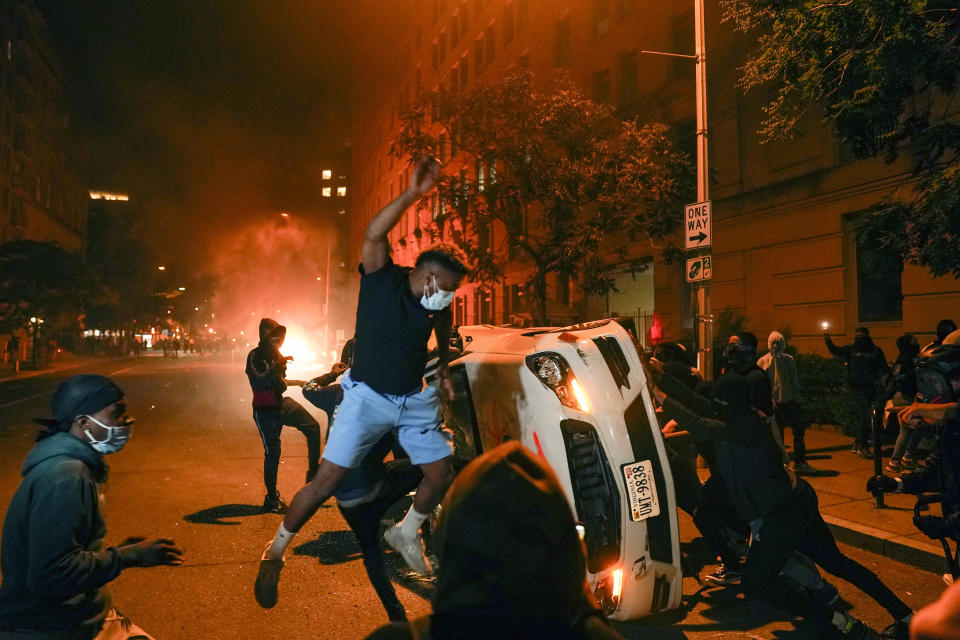 Demonstrators vandalize a car as they protest the death of George Floyd, Sunday, May 31, 2020, near the White House in Washington. Floyd died after being restrained by Minneapolis police officers. (AP Photo/Evan Vucci)