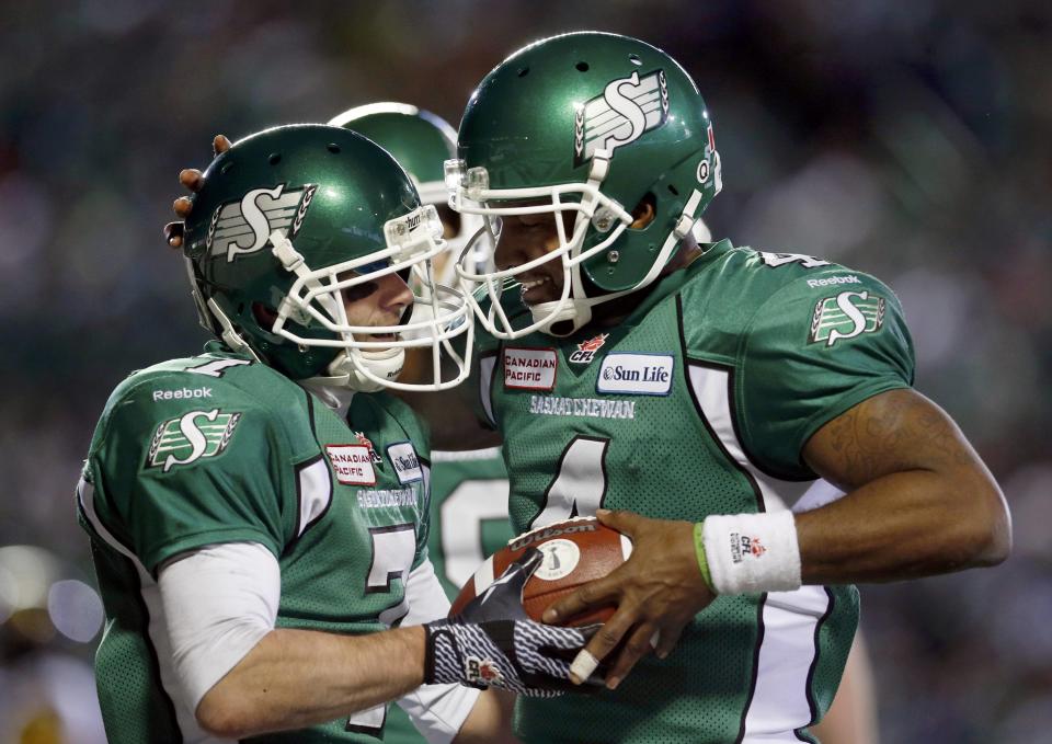 The Saskatchewan Roughriders Weston Dressler (L) gives the ball to quarterback Darian Durant after a touchdown against the Hamilton Tiger-Cats during the second half of the CFL's 101st Grey Cup championship football game in Regina, Saskatchewan November 24, 2013. REUTERS/Mark Blinch (CANADA - Tags: SPORT FOOTBALL)