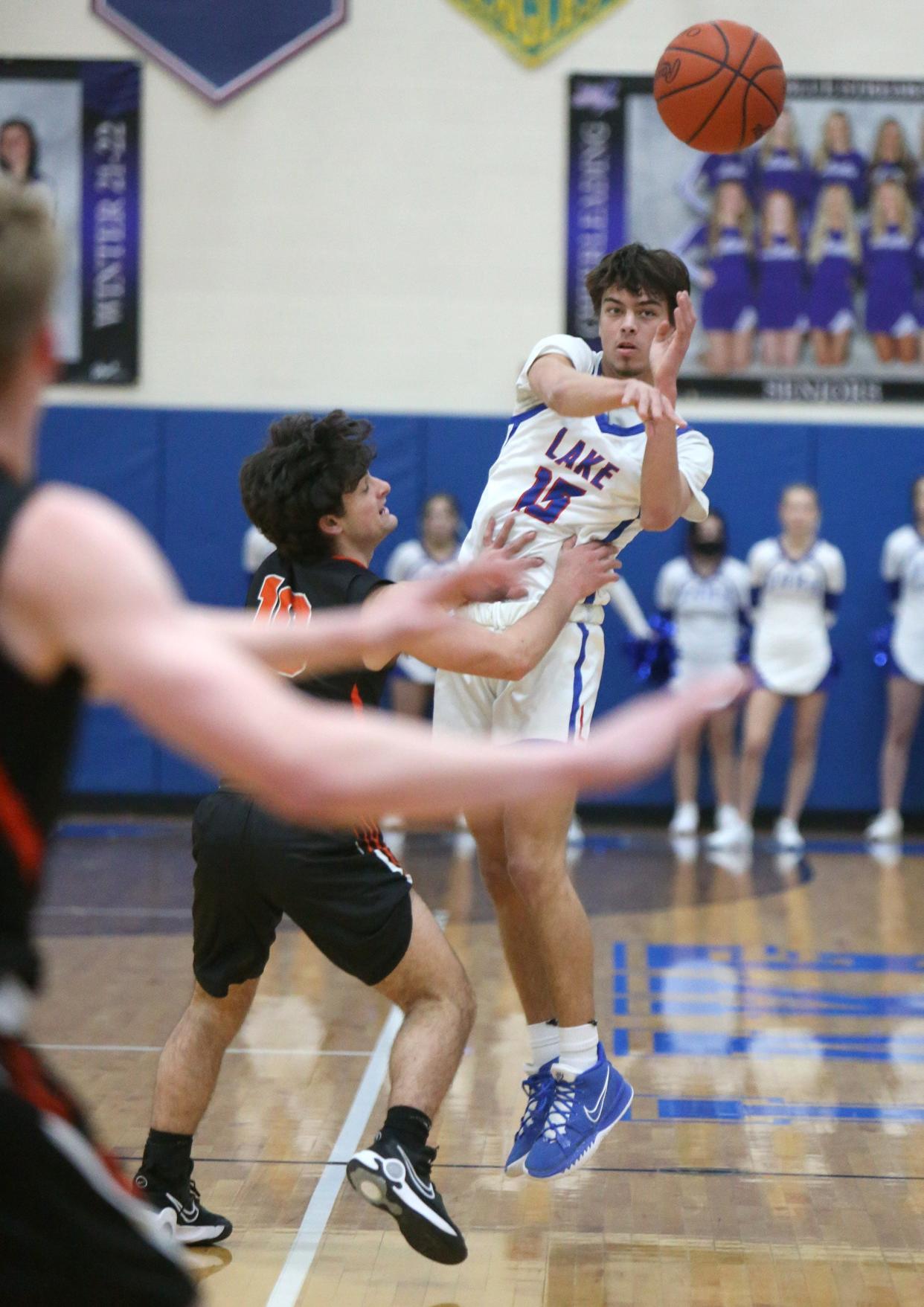 Landon Woods, right, of Lake passes while being guarded by Marc Adam, left, of Green during their game at Lake on Tuesday.