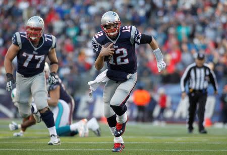 Dec 14, 2014; Foxborough, MA, USA; New England Patriots quarterback Tom Brady (12) carries the ball during the third quarter against the Miami Dolphins at Gillette Stadium. Mandatory Credit: Stew Milne-USA TODAY Sports