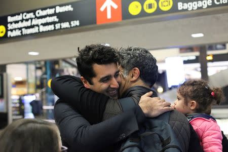 Iranian citizen and U.S green card holder Cyrus Khosravi (L) greets his brother, Hamidreza Khosravi (C), and niece, Dena Khosravi (R), 2, after they were detained for additional screening following their arrival to Seattle-Tacoma International Airport to visit Cyrus, during a pause in U.S. President Donald Trump's travel ban in SeaTac, Washington, U.S. February 6, 2017. REUTERS/David Ryder