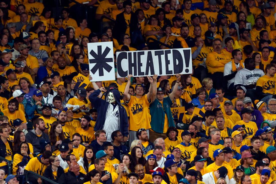 Seattle Mariners fans hold signs in 2015 referring to a steroid suspension New York Yankee Alex Rodriguez served.