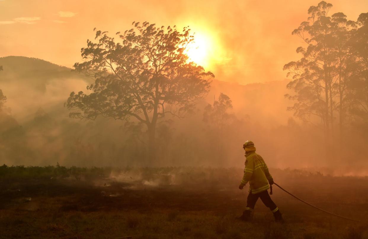 <span class="caption">With wildfires, droughts and extreme storms in many parts of the world, climate warnings are starting to feel personal.</span> <span class="attribution"><a class="link " href="https://www.gettyimages.com/detail/news-photo/firefighter-defends-a-property-from-a-bushfire-at-hillville-news-photo/1181879830" rel="nofollow noopener" target="_blank" data-ylk="slk:Peter Parks/AFP via Getty Images;elm:context_link;itc:0;sec:content-canvas">Peter Parks/AFP via Getty Images</a></span>