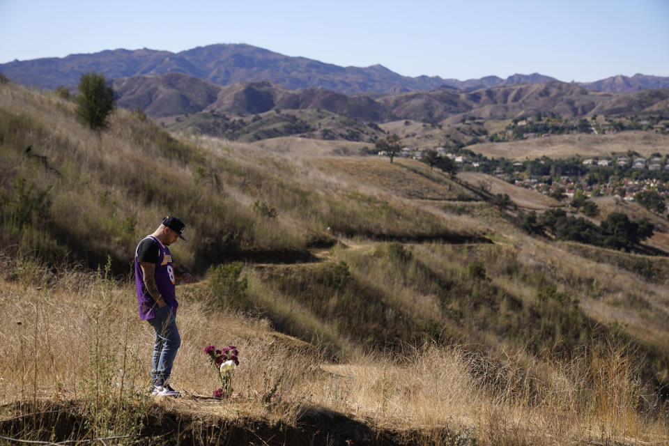 FILE - In this Jan. 26, 2021, file photo, Anthony Calderon wears a Kobe Bryant jersey in Calabasas, Calif., at the site of a helicopter crash that killed Bryant, his daughter Gianna, and seven others one year ago. Federal safety officials are expected to vote Tuesday, Feb. 9, 2021, on what likely caused the helicopter carrying Kobe Bryant, his 13-year-old daughter and seven others to crash into a Southern California hillside last year, killing all aboard. (AP Photo/Marcio Jose Sanchez, File)