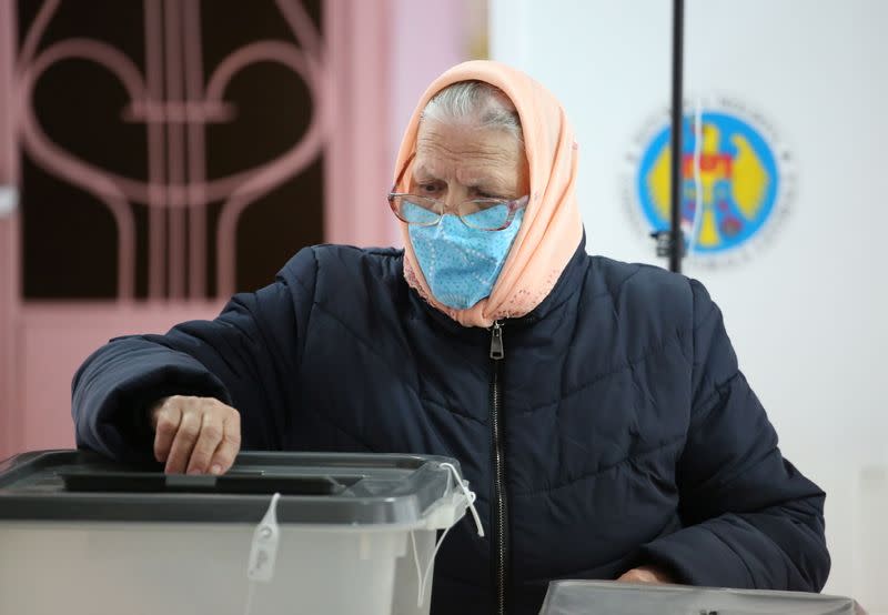 A woman casts her ballot at a polling station during the second round of a presidential election in Chisinau