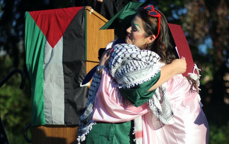 Andrea Herrera, pro tem instructor at the University of Oregon, hugs a graduate Friday during a commencement ceremony for "The Popular University for Palestine," those who participated in the pro-Palestinian encampment.