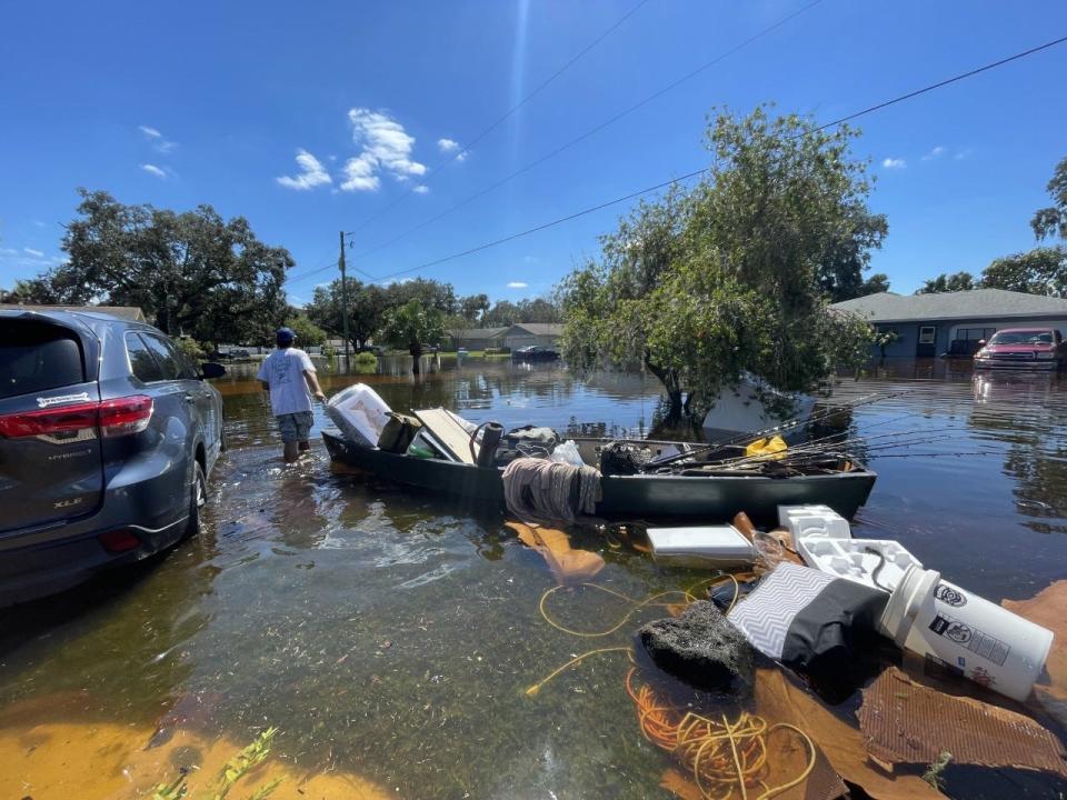 Hannah Herrero, of Green Road in New Smyrna Beach, and her partner try to salvage possessions, most of which were lost due to flooding in their home.