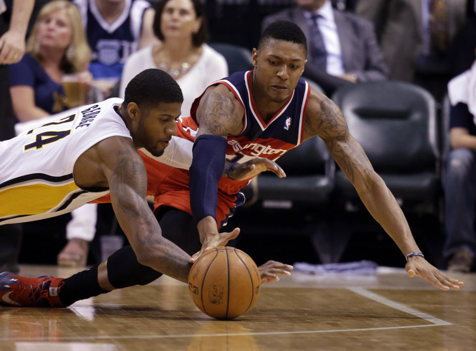 Washington Wizards guard Bradley Beal, right, and Indiana Pacers forward Paul George dives for a loose ball during the second half of game 5 of the Eastern Conference semifinal NBA basketball playoff series Tuesday, May 13, 2014, in Indianapolis. (AP Photo/Darron Cummings)