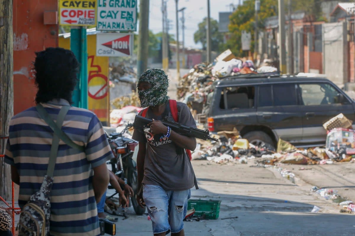 Armed gang members stand guard at their roadblock in Port-au-Prince, Haiti, on March 11 (AP)