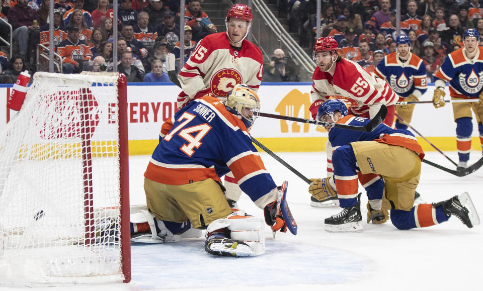 Calgary Flames' Noah Hanifin (55) scores against Edmonton Oilers goalie Stuart Skinner (74) during first-period NHL hockey game action in Edmonton, Alberta, Saturday, Feb. 24, 2024. (Jason Franson/The Canadian Press via AP)