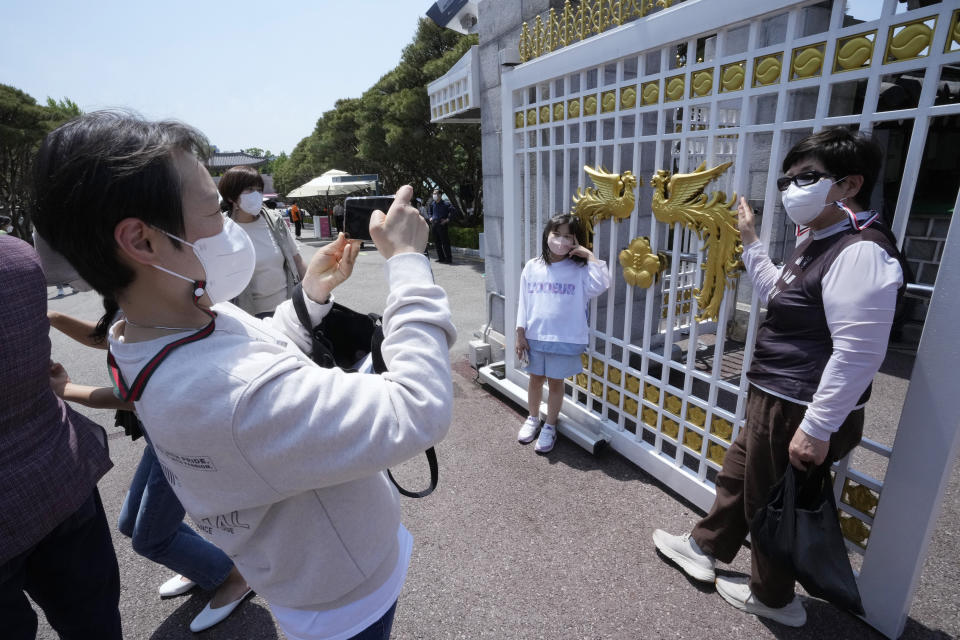 People take photos in front of the main entrance gate of the Blue House, the former presidential palace, in Seoul, South Korea, Thursday, May 12, 2022. For most South Koreans, the former presidential palace in Seoul was as shrouded in mystery as the buildings in their secretive rival North Korea. That’s now changed recently as thousands have been allowed a look inside for the first time in 74 years.(AP Photo/Ahn Young-joon)