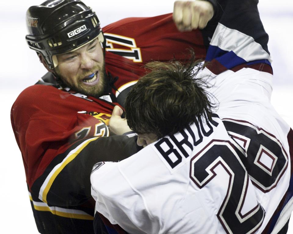 FILE -Vancouver Canucks Wade Brookbank, right fights with Calgary Flames Chris Simon during first period NHL hockey action in Calgary, Tuesday, Feb. 28, 2006. Former NHL enforcer Chris Simon has died. He was 52. Simon died Monday night, March 18, 2024, according to a spokesperson for the NHL Players' Association. (Jeff McIntosh/The Canadian Press via AP, File)