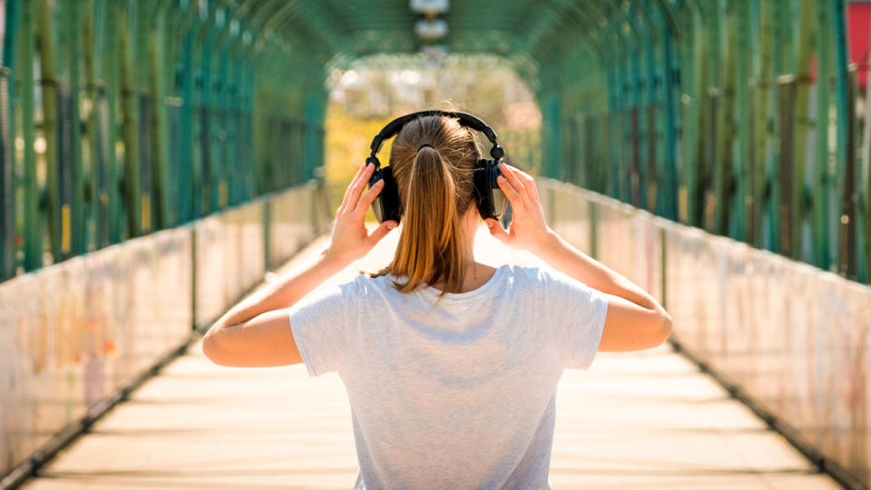 Black Friday headphones deals: The back of a woman adjusting her headphones