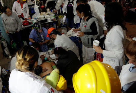 Paramedics attend to a rescue worker during a search for students at the Enrique Rebsamen school after an earthquake in Mexico City, Mexico September 21, 2017. REUTERS/Daniel Becerril