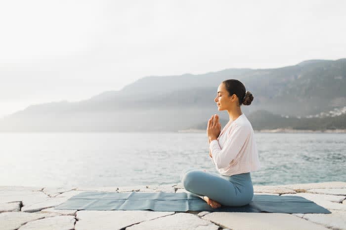 mujer haciendo yoga al aire libre