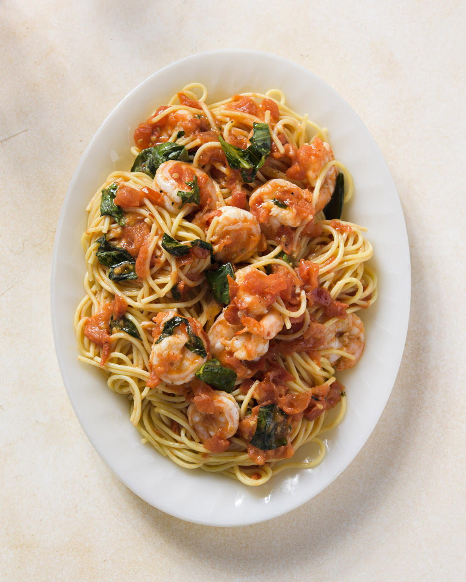 This image released by Milk Street shows a recipe for spaghetti with shrimp, tomatoes and white wine. (Milk Street via AP)