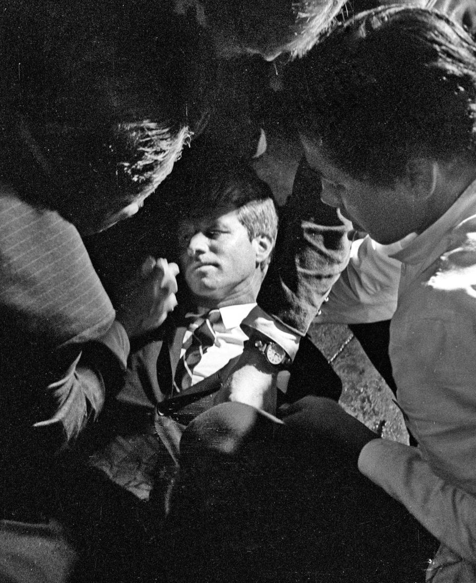 In this June 5, 1968 file photo, Hotel busboy Juan Romero, right, comes to the aid of Senator Robert F. Kennedy, as he lies on the floor of the Ambassador hotel in Los Angeles moments after he was shot. Source: Richard Drew/Pasadena Star News via AP