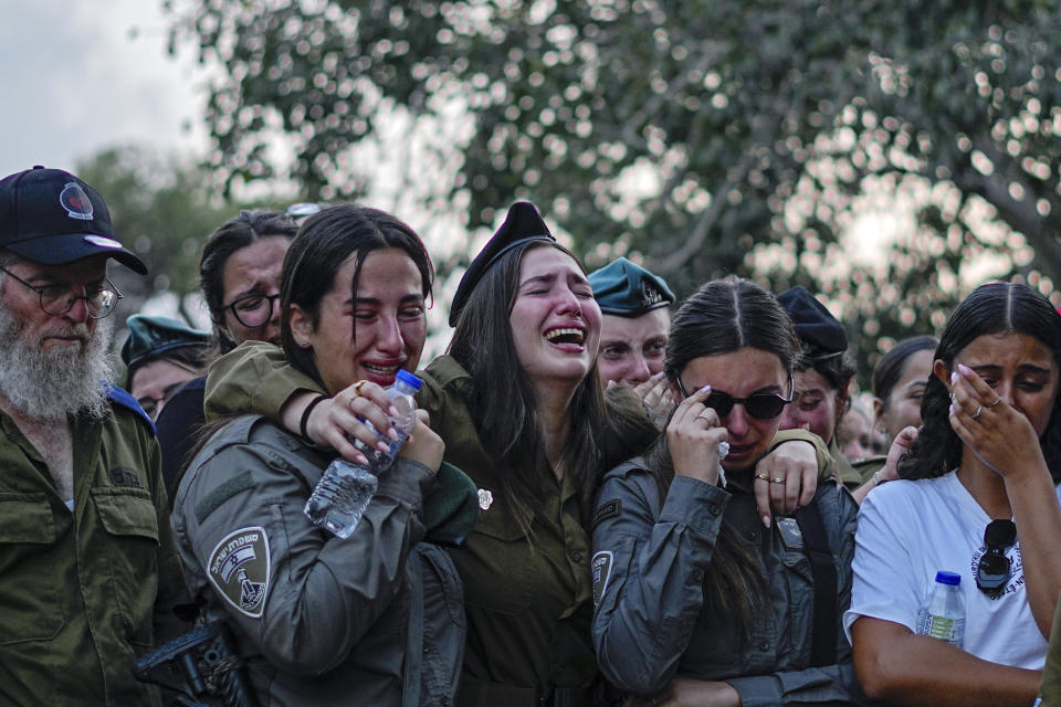 Mourners gather around the graves of Sgt. Yam Goldstein and her father, Nadav, during their funeral in Kibbutz Shefayim, Israel, Monday, Oct. 23, 2023. Yam and her father were killed by Hamas militants on Oct. 7 at their house in Kibbutz Kfar Azza near the border with the Gaza Strip. The rest of the family are believed to be held hostage in Gaza. (AP Photo/Ariel Schalit)