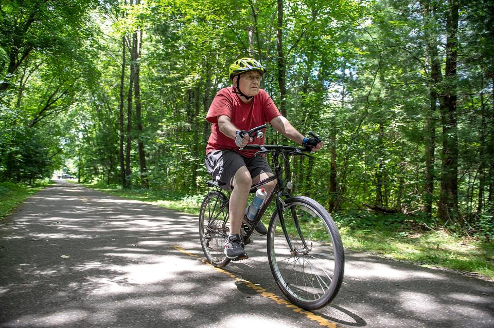 John Holzhauer, of Hudson, pedals along the Assabet River Rail Trail in Hudson, July 7, 2022.