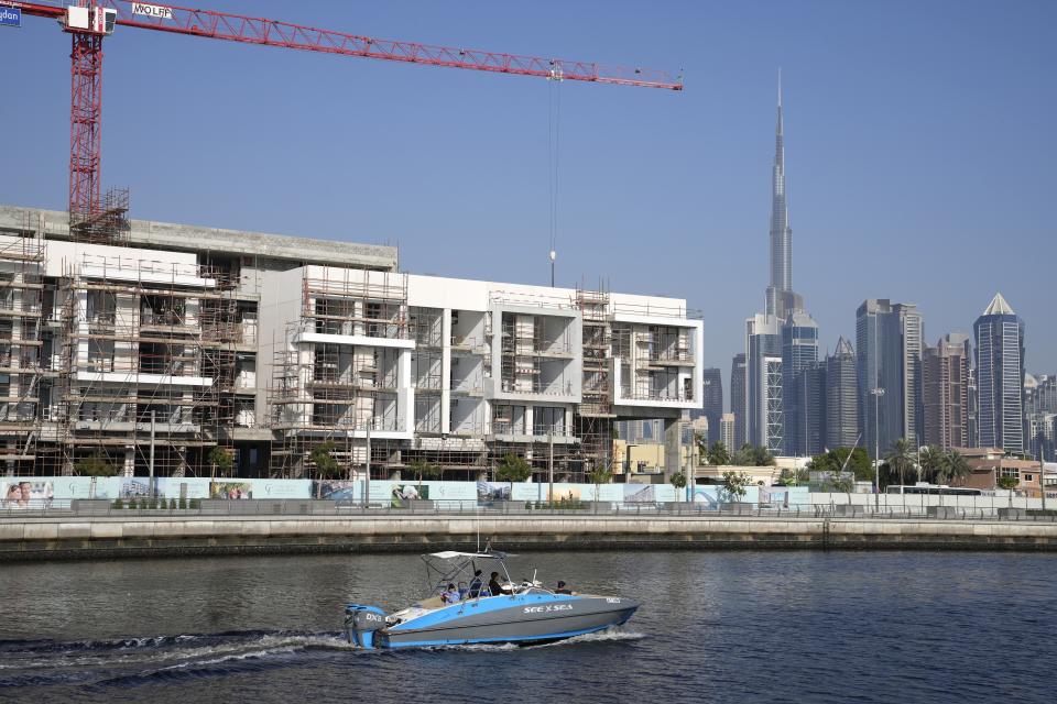 A boat moves on the Dubai Water Canal while passing in front a new residential project in Dubai, United Arab Emirates, Tuesday, Jan. 31, 2023. For the first time since a 2009 financial crisis nearly brought Dubai to its knees, several major abandoned real estate projects now show signs of life. As with its other booms, war again is driving money into Dubai and buoying its economy. This time it's Russian investors fleeing Moscow’s war on Ukraine, rather than people escaping Mideast battlefields. (AP Photo/Kamran Jebreili)