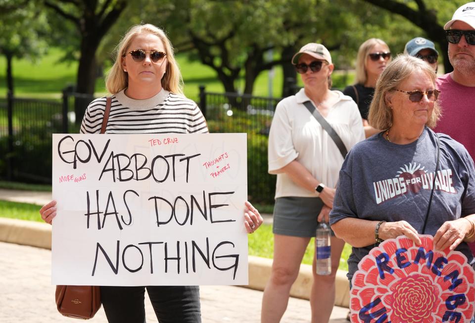 Nicholette Menzel holds a sign at a memorial for the victims of the Uvalde school shooting at the Governor’s Mansion on Wednesday May 24, 2023.  Dozens of people gathered to remember the children and teachers on the one year anniversary of the shooting.