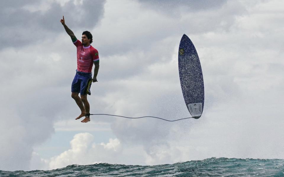 Brazil's Gabriel Medina reacts after getting a large wave in the fifth heat of the men's surfing and appears to be walking in the air