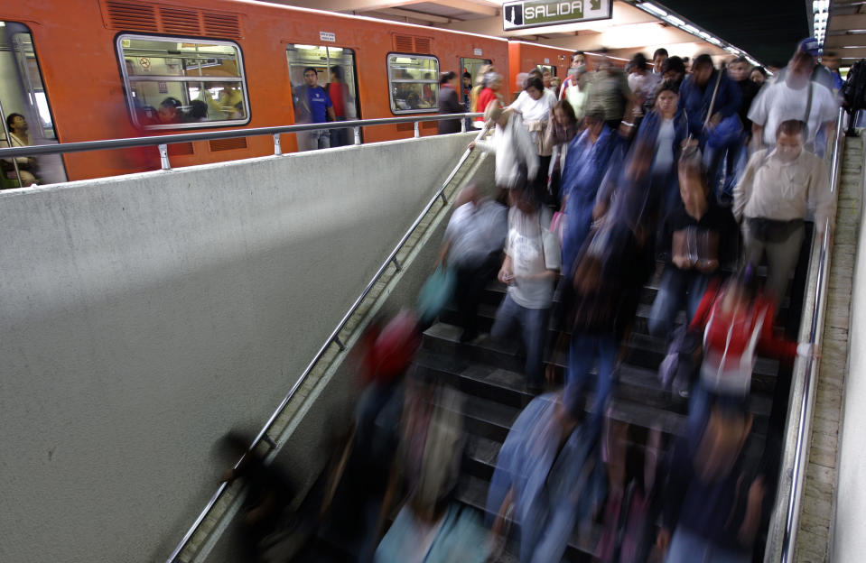 Commuters go downstairs 10 October 2007 at Indios Verdes subway station in Mexico City. The subway service of the overpopulated Mexican capital presently transports 4,3 million commuters a day, one million less than 15 years ago, PRI's local deputy and former subway union leader Fernando Espino said to AFP.      AFP PHOTO/Ronaldo SCHEMIDT (Photo credit should read Ronaldo Schemidt/AFP/Getty Images)