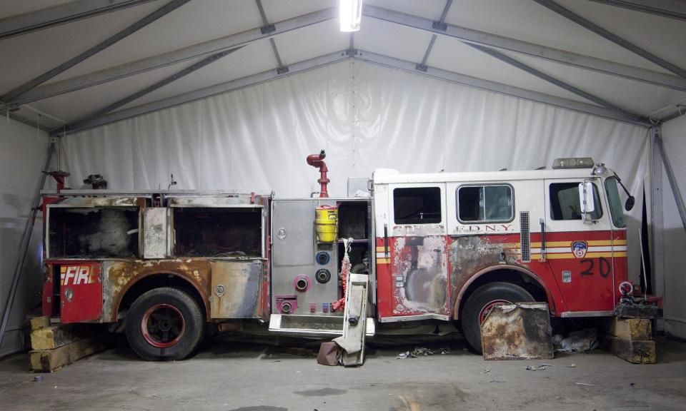 FILE - In this file photo of June 19, 2011, a damaged New York Fire Department truck is stored in Hangar 17 at John F. Kennedy International Airport in New York. The truck is part of the collection of artifacts for the National September 11 Museum. The long-awaited museum dedicated to the victims of the Sept. 11 terror attacks will open to the public at the World Trade Center site on May 21, officials announced Monday, March 24, 2014. (AP Photo/Mark Lennihan, File)