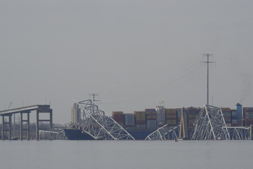 A container ship rests against wreckage of the Francis Scott Key Bridge on Tuesday, March 26, 2024, as seen from Sparrows Point, Md. The ship rammed into the major bridge in Baltimore early Tuesday, causing it to collapse in a matter of seconds and creating a terrifying scene as several vehicles plunged into the chilly river below. (AP Photo/Matt Rourke)