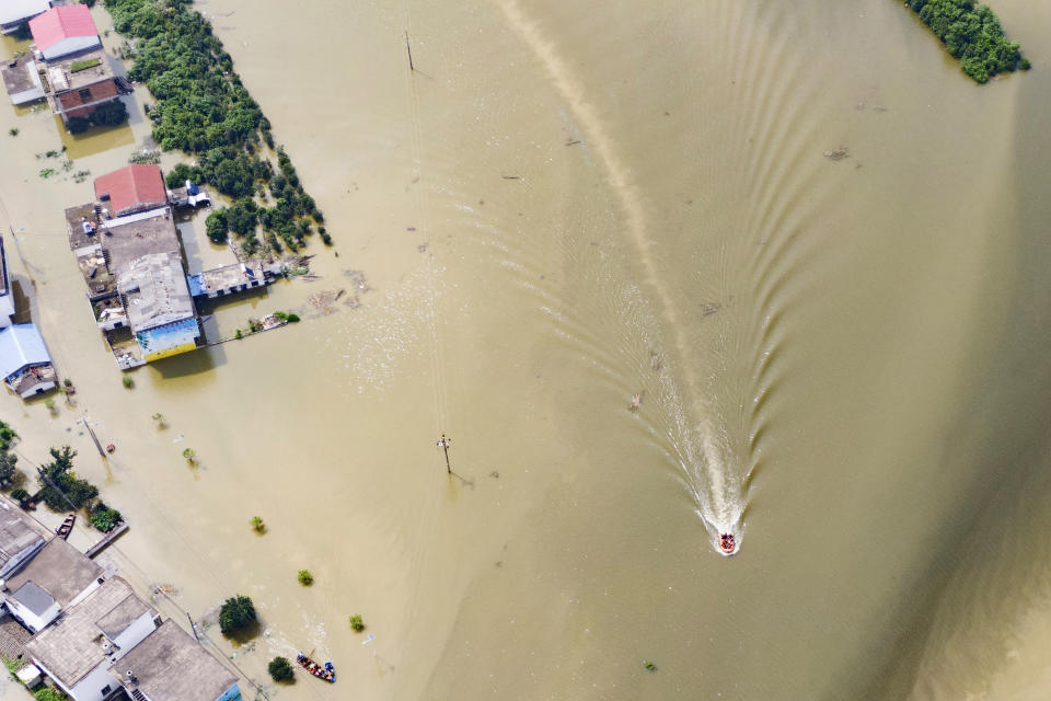 In this aerial photo released by Xinhua News Agency, rescue workers on a raft are seen moving through flood waters to help evacuate trapped residents in Sanjiao Township of Yongxiu County in central eastern China's Jiangxi Province on Monday, July 13, 2020. Engorged with more heavy rains, China's mighty Yangtze River is cresting again, bringing fears of further destruction. (Zhang Haobo/Xinhua via AP)