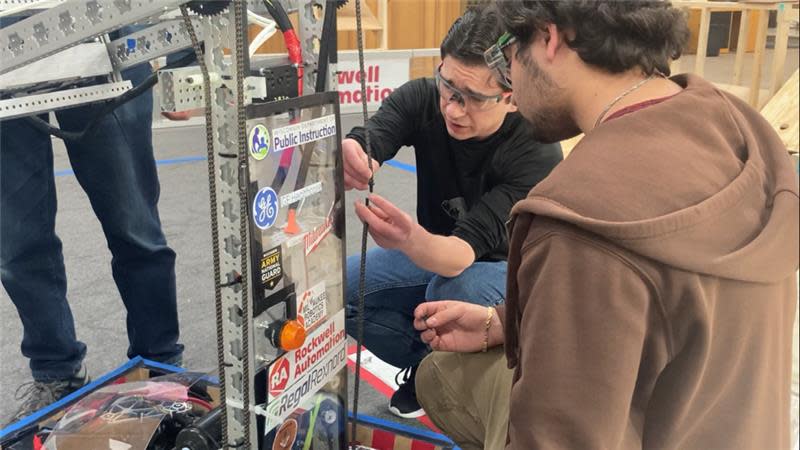 Erik Orlowski working on a robot with a Riverside University High School robotics team member.