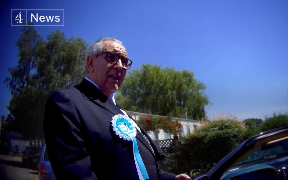 Man in his 60s in a suit with a Reform rosette