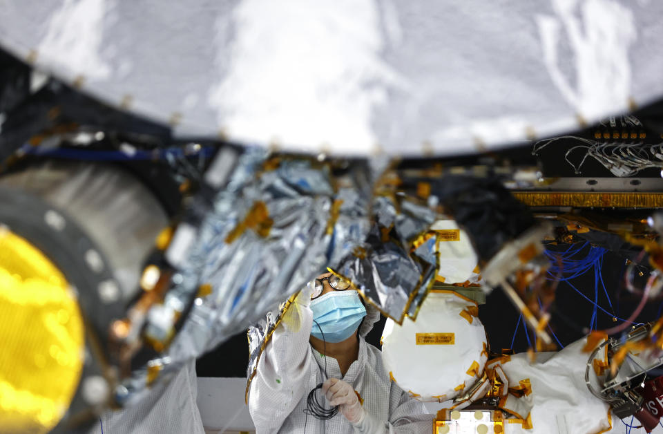 PASADENA, CALIFORNIA - APRIL 11: A clean room engineer prepares the Psyche mission spacecraft inside a Spacecraft Assembly Facility clean room at NASA's Jet Propulsion Laboratory (JPL) on April 11, 2022 in Pasadena, California. The NASA spacecraft is scheduled to launch in August on a solar-powered 1.5 billion mile journey toward the giant metal-rich asteroid Psyche, which it will begin orbiting for study in 2026. Scientists believe the mysterious asteroid might be the exposed core of an ancient planet and hope to learn more about Earth’s own metal core and the formation of Earth’s solar system.  (Photo by Mario Tama/Getty Images)