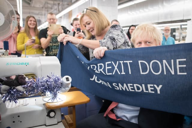 Boris Johnson with a Get Brexit Done banner during a visit to the John Smedley Mill in Matlock