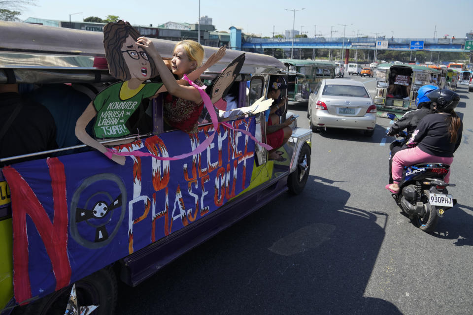 An activist arranges a slogan on a passenger jeepney during a transport strike in Quezon city, Philippines on Monday, March 6, 2023. Philippine transport groups launched a nationwide strike Monday to protest a government program drivers fear would phase out traditional jeepneys, which have become a cultural icon, and other aging public transport vehicles. (AP Photo/Aaron Favila)