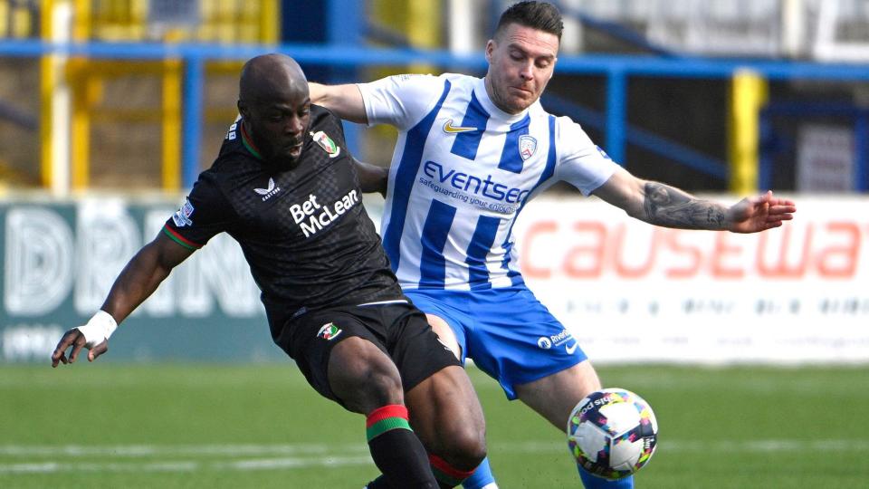 Fuad Sule battles for possession with Josh Carson