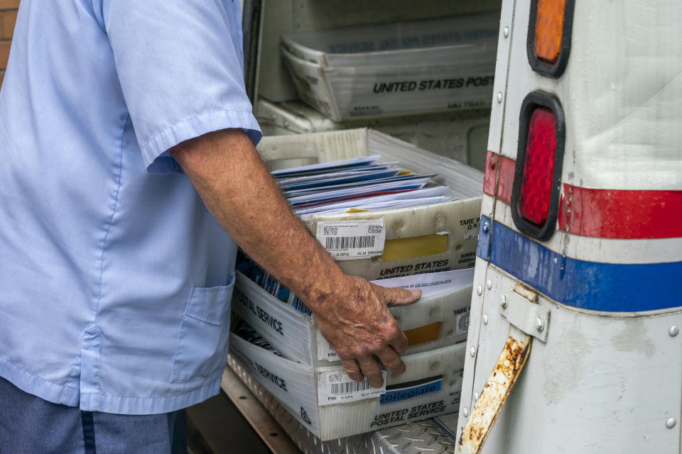 FILE - In this July 31, 2020, file photo, letter carriers load mail trucks for deliveries at a U.S. Postal Service facility in McLean, Va. The success of the 2020 presidential election could come down to a most unlikely government agency: the U.S. Postal Service. (AP Photo/J. Scott Applewhite, File)