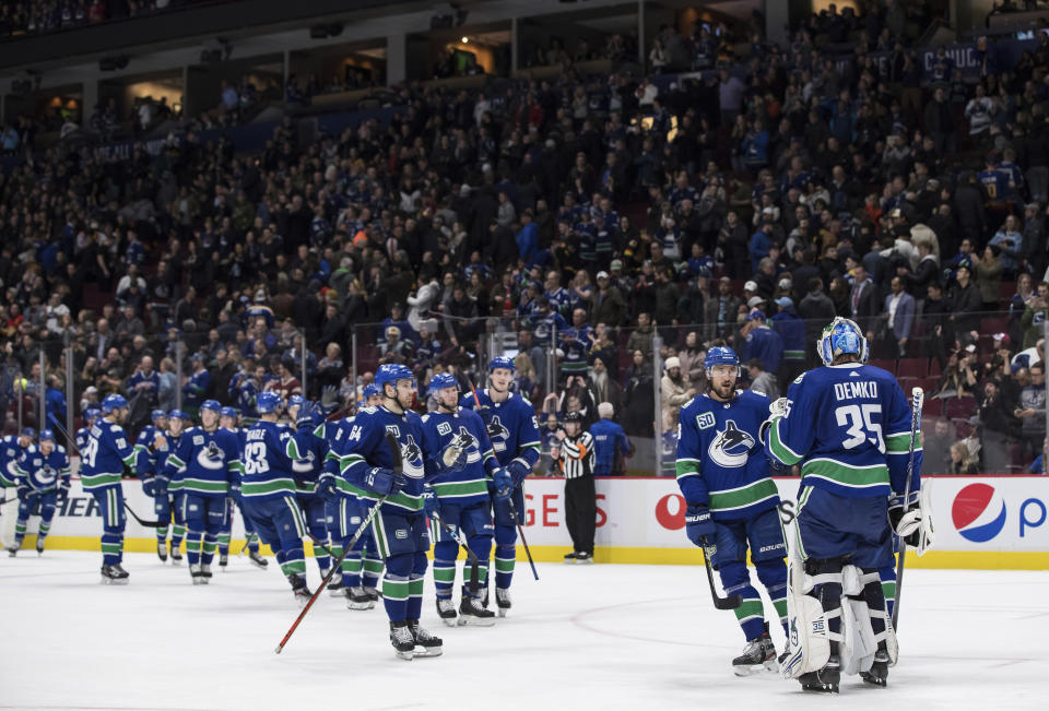 Vancouver Canucks goalie Thatcher Demko (35) and his teammates celebrate after defeating the St. Louis Blues 3-1 during an NHL hockey game in Vancouver, British Columbia, Monday, Jan. 27, 2020. (Darryl Dyck/The Canadian Press via AP)