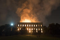 People watch as flames engulf the 200-year-old National Museum of Brazil, in Rio de Janeiro, Sunday, Sept. 2, 2018. According to its website, the museum has thousands of items related to the history of Brazil and other countries. The museum is part of the Federal University of Rio de Janeiro. (AP Photo/Leo Correa)