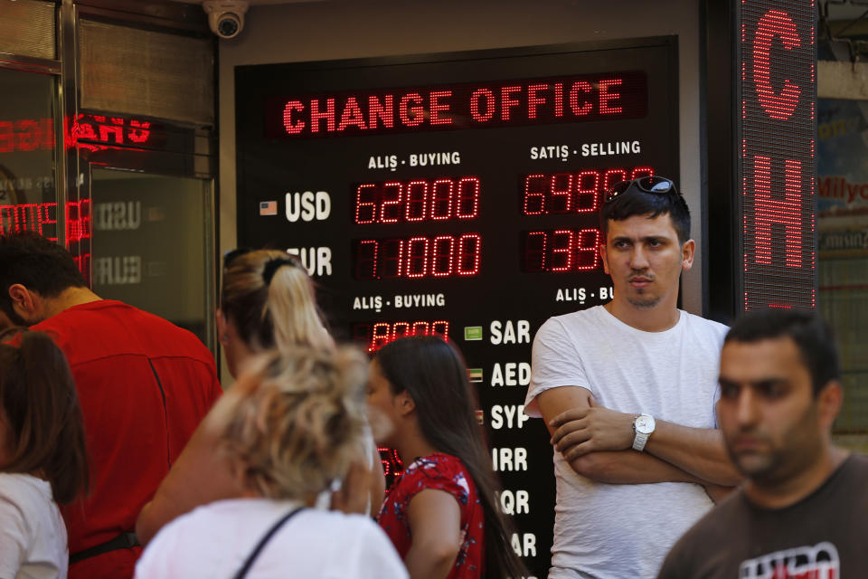 FILE- In this Tuesday, Aug. 14, 2018, file photo people line up at a currency exchange shop in Istanbul. Investors have been pulling out of Turkey’s markets, sending its stock market and currency plunging. That’s making debt that Turkish companies owe in dollar terms even more expensive to pay back, which only further weakens the country’s financial system. (AP Photo/Lefteris Pitarakis, File)
