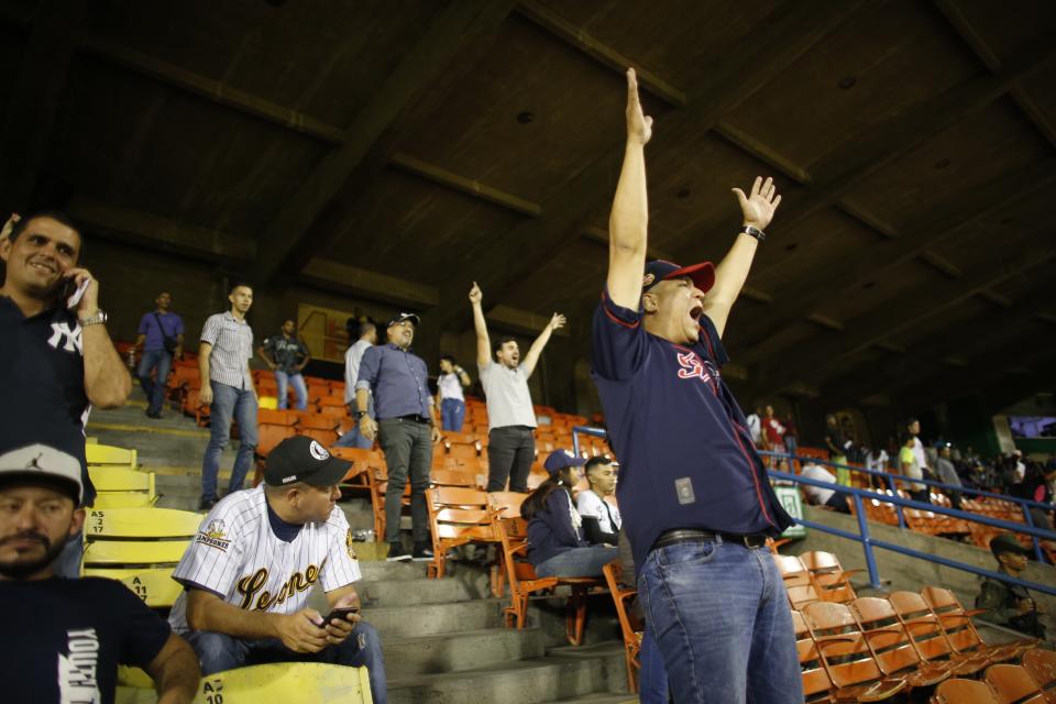 A fan of Leones de Caracas screams during the opening winter league baseball game against Tigres de Aragua in Caracas, Venezuela, Tuesday, Nov. 5, 2019. Venezuela’s beloved Winter League baseball season opened Tuesday with hundreds of cheering fans converging on the stadium in Caracas and elsewhere throughout the crisis-torn South American nation. (AP Photo/Ariana Cubillos)